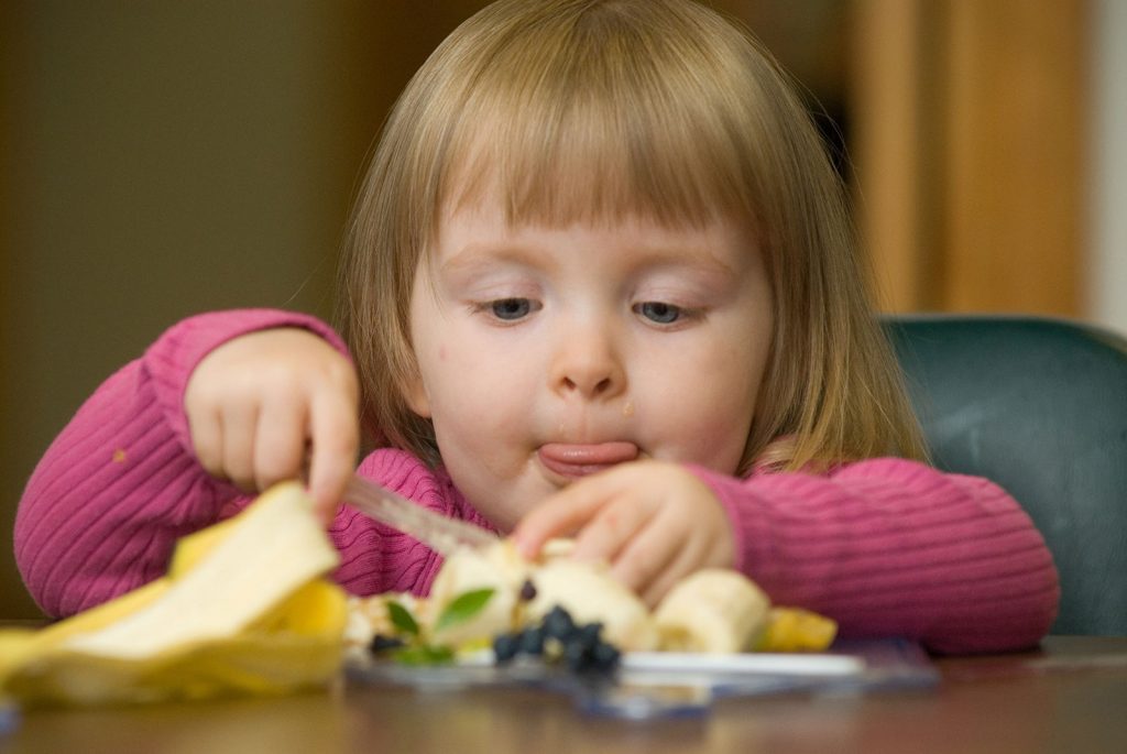 Young girl eating fruit