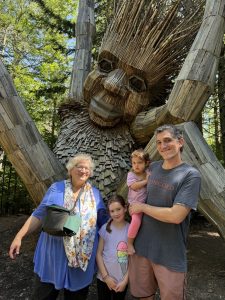 family posed in front of a troll statue at the Coastal Botanical Gardens