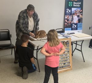 a volunteer showing t youth a brown rabbit
