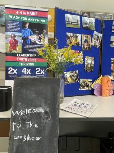 Welcome to the art show sign with many photos