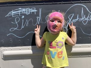 Girl with mask on in front of the Joy Truck