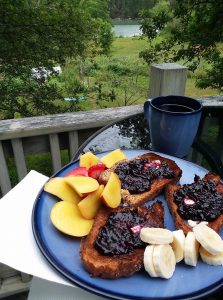 breakfast on the deck of a cottage overlooking gardens and a cove