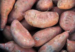 a close up of uncooked sweet potatoes at the market