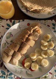 plate of crepes with sliced bananas for breakfast