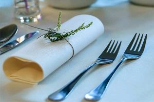 a formal place setting with forks on the side, ready to serve dinner