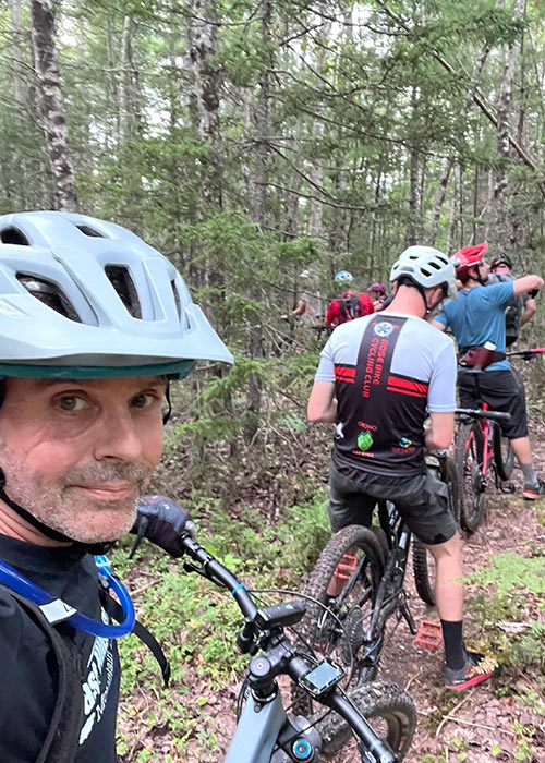 Matt Hawkyard out on a forest trail, mountain biking with others