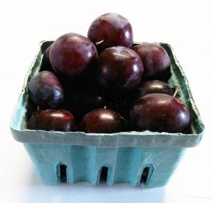 Quart-sized container filled with plums