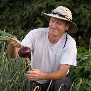 John Jemison harvesting onions in a community garden