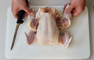 Photo showing how to cut the skin between the thigh and body.