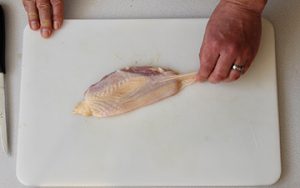 Photo of raw chicken and how to remove the skin.