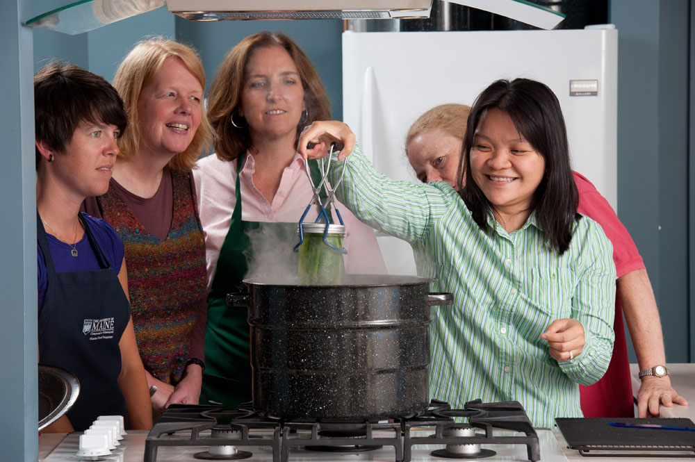 Extension staff and class participants learn about hot water bath canning; photo by Edwin Remsberg