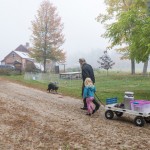farm family and goats in foggy pasture
