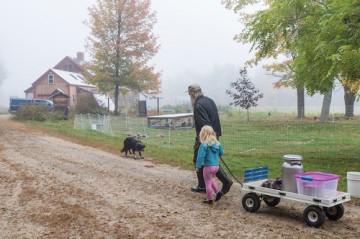 farm family and goats in foggy pasture