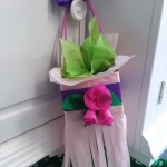 Basket made from colorful tissue paper hanging from door knob