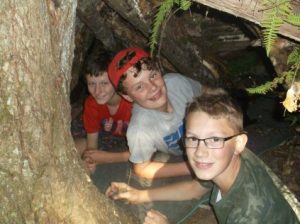 3 youth in a shelter in the woods