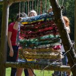 campers weave on a loom made of natural materials