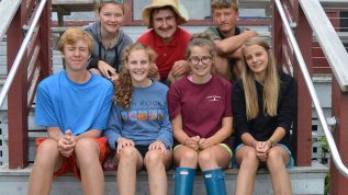 group of teen leaders sitting on camp steps