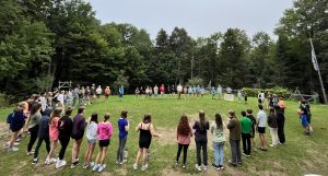 People stand in a circle on a field