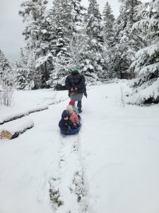 Educator pulling young explorers in a sled