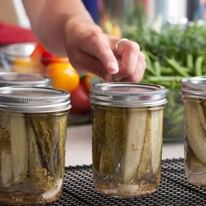 Master Food Preserver with canning jars of pickles