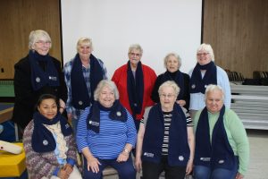 Senior Companion volunteers wearing their 40th anniversary scarves.