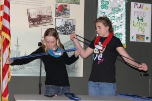 4-H members demonstrate how to make a scarf during the 4-H Public Speaking presentation at the WCEA Annual Meeting on April 7.