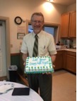 John Rebar with a cake for his retirement