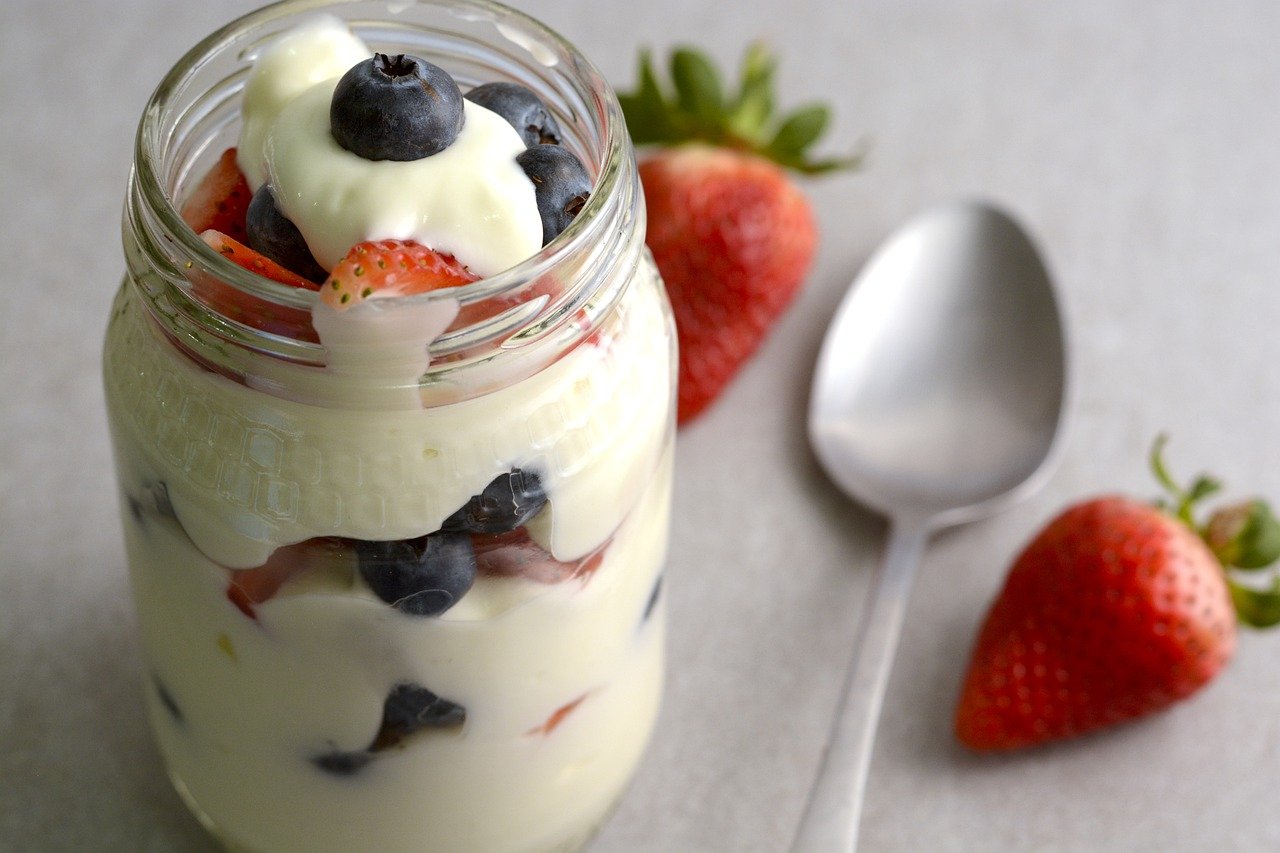 yogurt and berries in mason jar with spoon