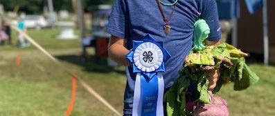 youth holds garden exhibit and ribbon