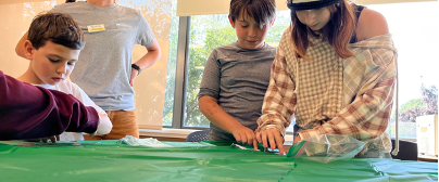 three youth and 4-H professional making fish prints
