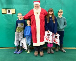 4-H members stand with Santa