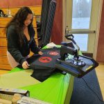 teen works with screen printing equipment