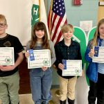 Four 4-H youth display their certificates and ribbons.