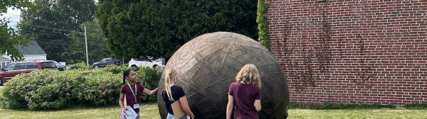 youth standing around a sculpture