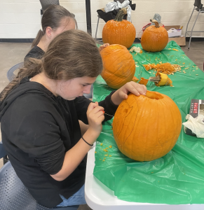 4-H'er carving a pumpkin.