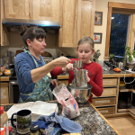 volunteer and youth mixing cookies