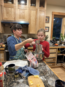 volunteer and youth mixing cookies