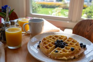 breakfast items: orange juice, coffee and blueberry waffle available at a Portland, Maine inn
