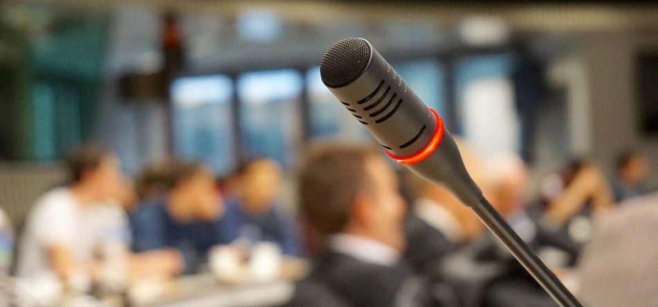 microphone at a conference with an audience in the background