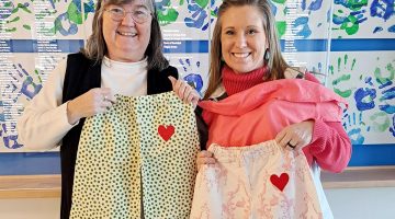 Extension Homemakers State Director Lisa Fishman delivers pajamas to Nicole Cooley, Development Director of the Boys and Girls Clubs of Kennebec County.