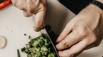 hands holding a knife chopping vegetables