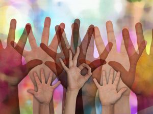 abstract image of hands raised representing people volunteering to help