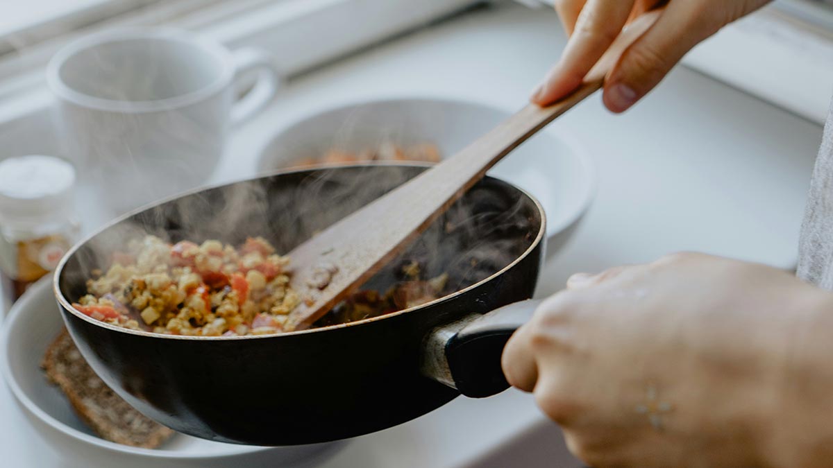 hands cooking a nutritious meal in a frying pan
