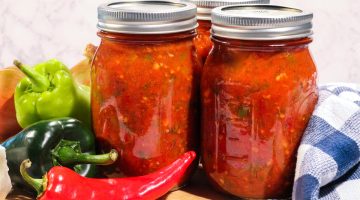 salsa in jars surrounded by peppers