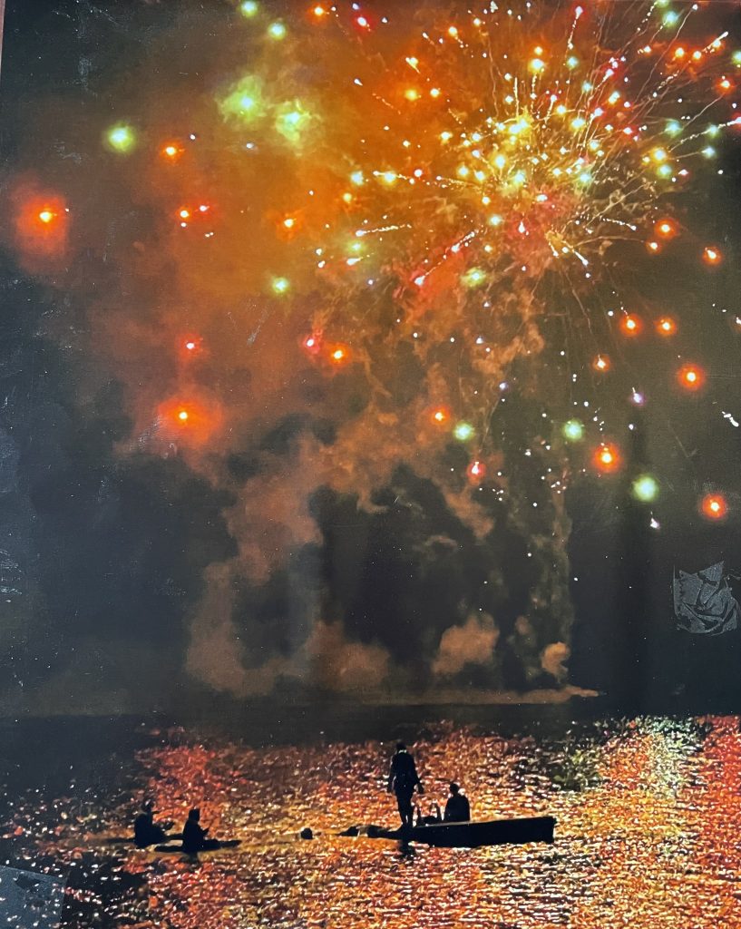 fireworks over water with people watching from a dock