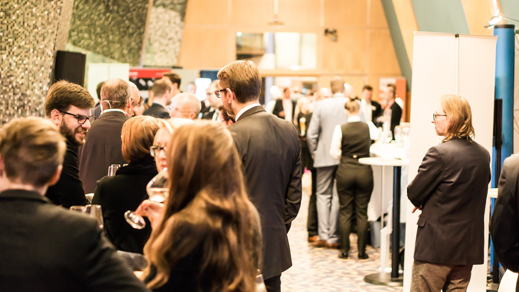 a crowd of conference attendees in an exhibition hall