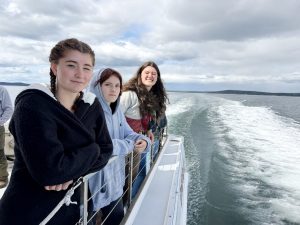 Three teens posing on a boat.