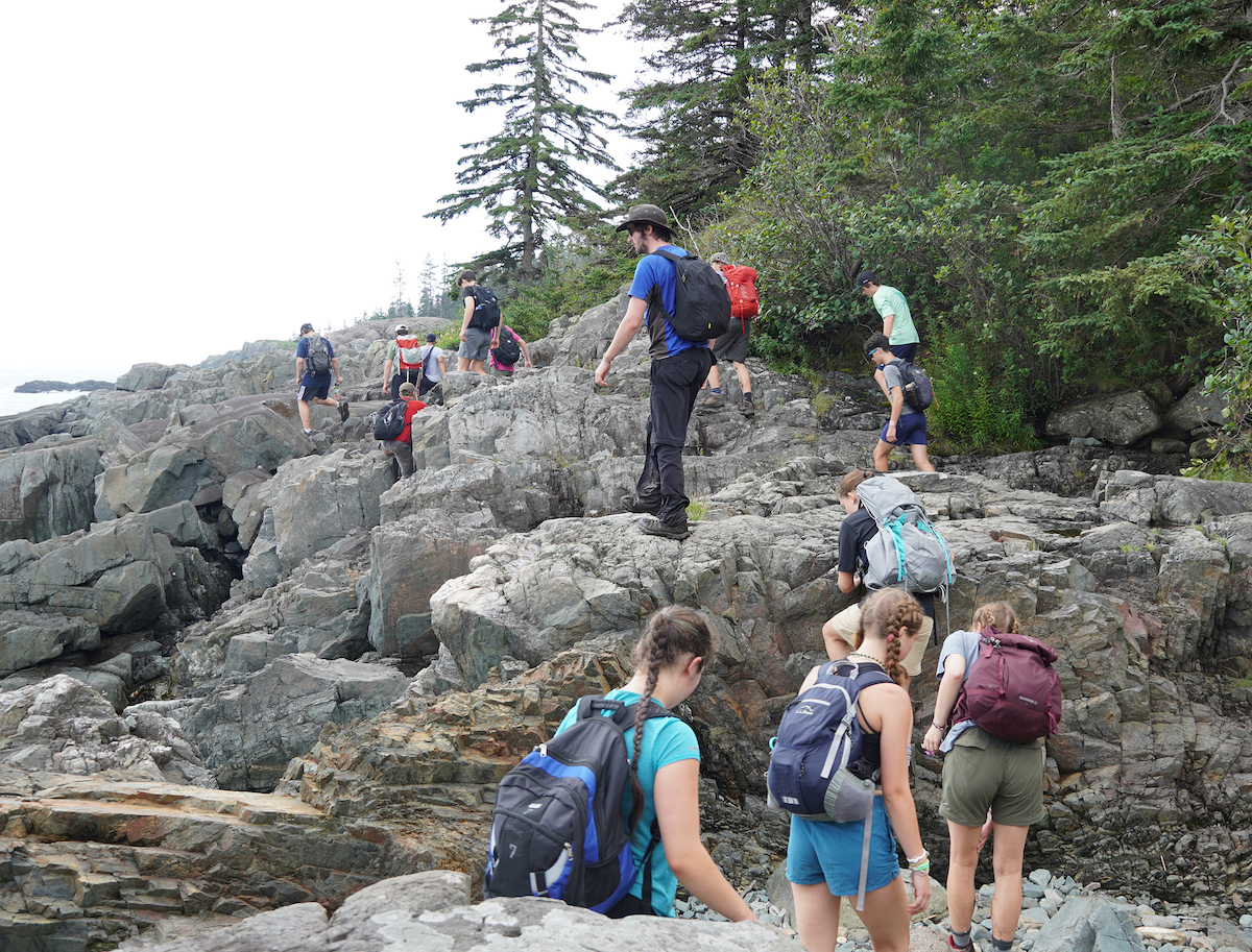 Teenagers hiking on a rocky coastline