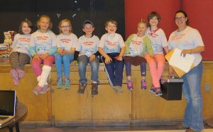 Nature Kids 4-H Club members sitting on a stage