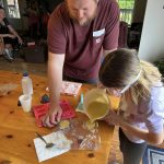 Kidding Around 4-H Member pouring soap mixture into molds with Leader Nate Cole.